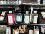 many different types of candles on the shelves in the store