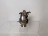 a silver pitcher sitting on a glass table