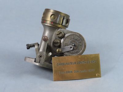 un petit objet métallique sur lequel est fixée une plaque en laiton