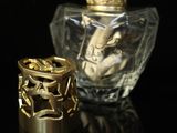 a bottle of perfume and a ring sitting on a table