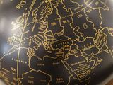 a black and gold globe with a map on it