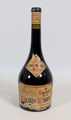 une vieille bouteille d'alcool posée sur une surface blanche
