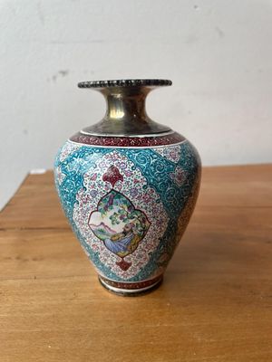 un petit vase posé sur une table en bois, avec un mur blanc en arrière-plan