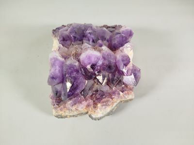 purple amethoral crystals on a white surface with a white background