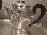 a silver tea pot sitting on top of a silver tray