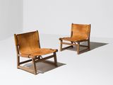 deux fauteuils en cuir marron dans une pièce blanche aux murs blancs