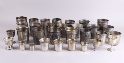 Plusieurs coupes en argent sont disposées en cercle sur une surface blanche