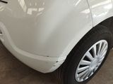 a close up of a white car with a denting on it