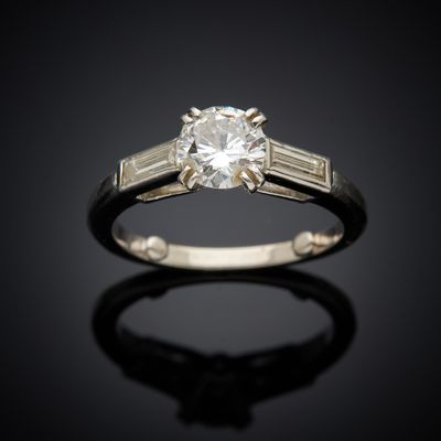 a close up of a diamond ring on a black surface