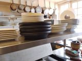 une pile d'assiettes posée sur une étagère métallique dans une cuisine