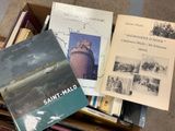 several books are stacked on top of each other in a box
