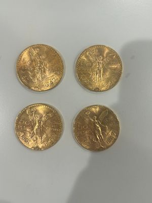 quatre pièces d'or posées sur une surface blanche
