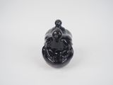 an image of a small black figurine sitting on top of a white surface