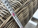 someone is measuring the height of a wicker chair with a tape measure