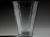 a glass vase sitting on a table with a shadow on the floor