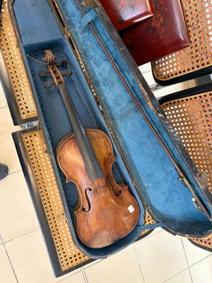 un violon dans son étui, posé sur une chaise