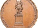 an image of a bronze medal with a statue of a man on a pedestal