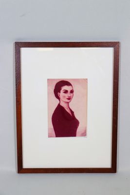 Une vieille photo d'une femme en robe noire est accrochée au mur.