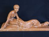 sculpture of a woman laying on a man ' s back