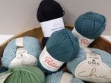 many balls of yarn in a wooden bowl on a table