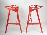 une paire de tabourets en métal rouge sur fond blanc