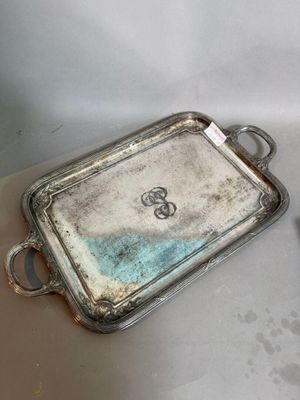 two silver trays sitting on a table next to each other