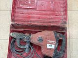 une boîte à outils rouge contenant un marteau électrique