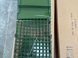 a green bird cage with a green bird inside of it