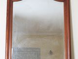 a mirror sitting on top of a dresser in a room