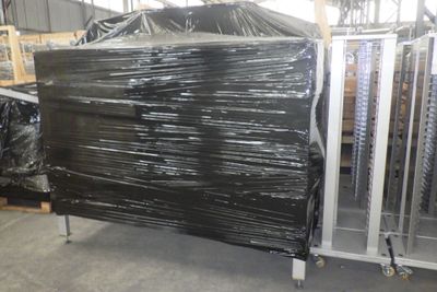 un gros tas de plastique noir emballé dans un entrepôt