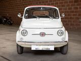 a small white car parked in front of a brick wall