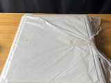 a plastic sheet wrapped around a laptop on a wooden table