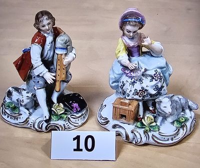 deux figurines représentant un garçon et une fille assis sur un rocher
