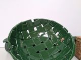 a green basket sitting on a table next to a wicker basket