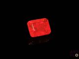 a red diamond on a black surface with a black background
