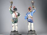 pair of figurines of two men with lamps on their heads
