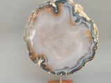 une photo d'une agate blanche et bleue posée sur un socle en bois