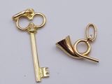 a gold key and a gold horn on a white surface