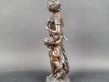bronze statue of a woman holding a child on a rock