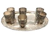 quatre coupes en argent posées sur un plateau en argent, sur fond blanc