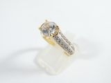 an image of a gold and diamond ring on a white surface