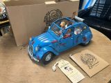 a blue toy car sitting on top of a table next to a cardboard box