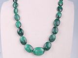 a necklace made of green glass beads on a mannequin