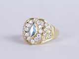un gros plan d'une bague en or sertie d'une pierre bleue entourée de diamants blancs