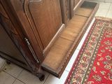 un tapis rouge posé à même le sol, à côté d'une armoire en bois