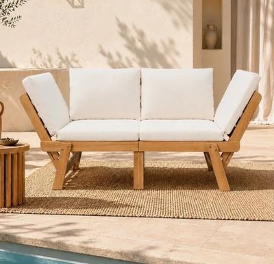 une photo d'un canapé blanc posé sur un tapis, près d'une piscine