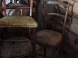 many chairs and a table in a room with old furniture
