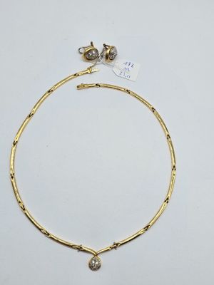 a gold necklace with a small diamond on it