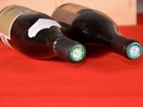 two bottles of wine sitting on a red table