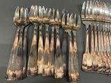 a lot of forks and spoons that are on the table